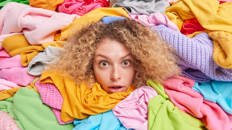 Stop al fast fashion: una ragazza sommersa dagli abiti